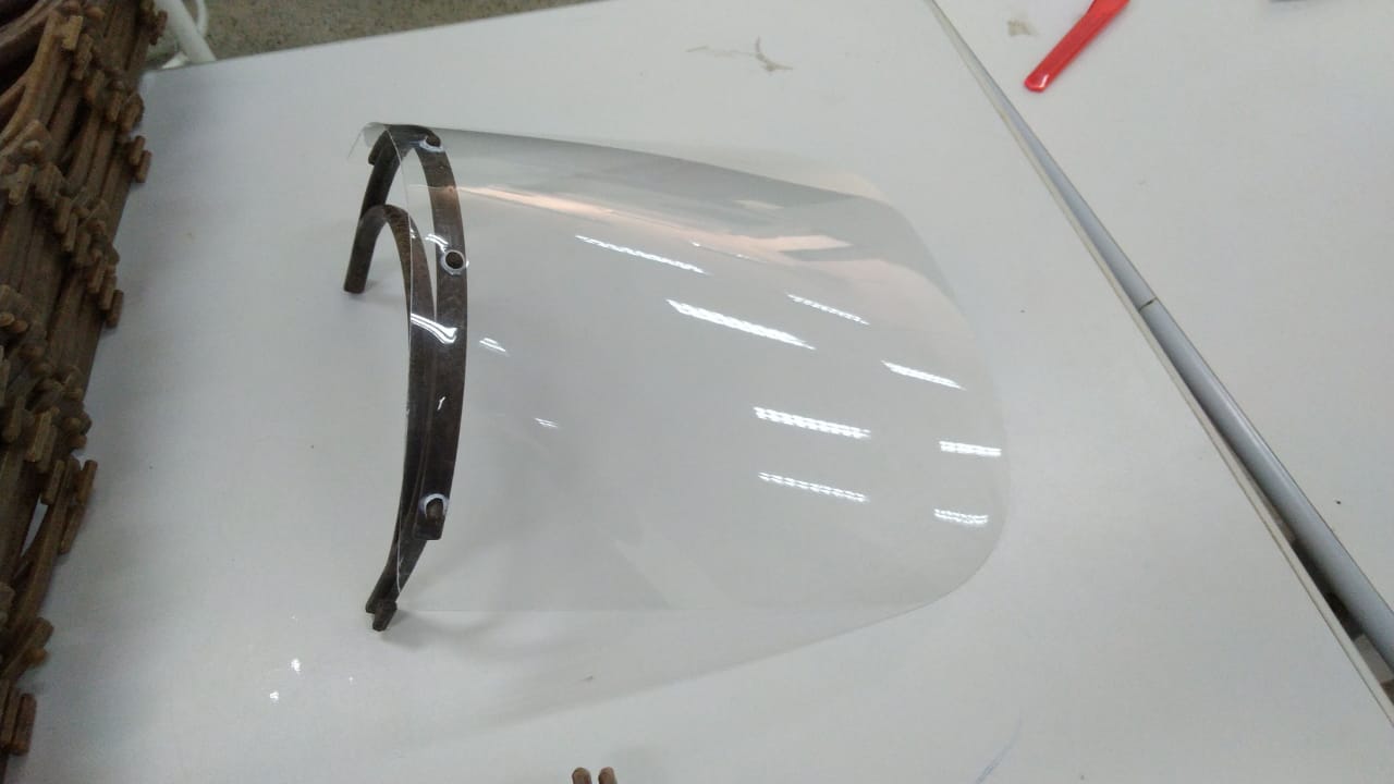 Máscara face shield em cima de uma mesa branca